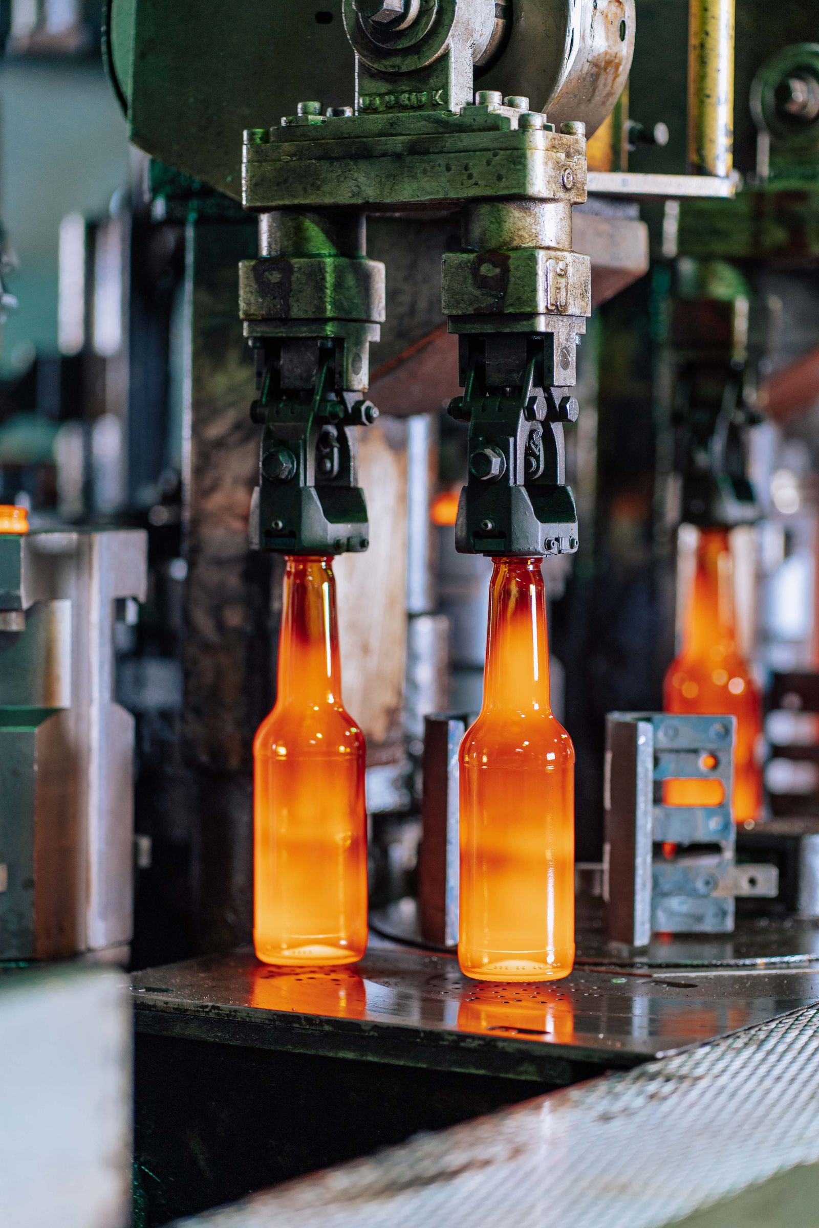 Molten glass bottles being formed on the production line
